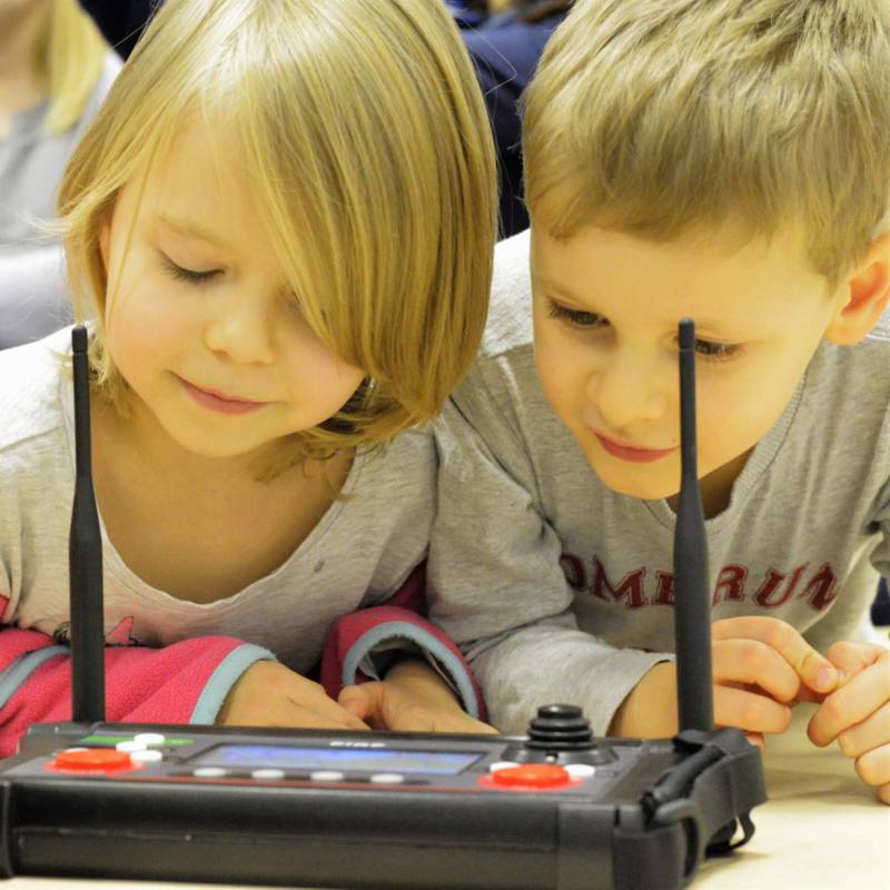Dzieci przyglądają się panelowi operatorskiemu do robota pirotechnicznego PIAP